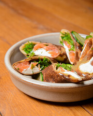 Stack of pancakes with salted salmon and cream cheese Philadelphia in a bowl. Over rustic wooden background.