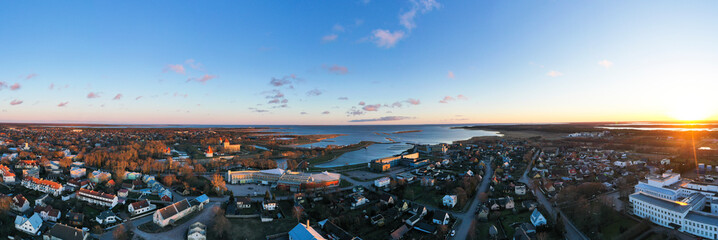 Aerial view to the sunset colored coastal historic medieval fortress with the surrounding water...