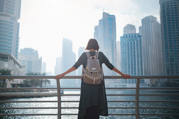 Happy young female traveler in the big city of Dubai, UAE