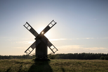Fototapeta na wymiar Scenic silhouette view to the traditional wooded windmill in the sunset light