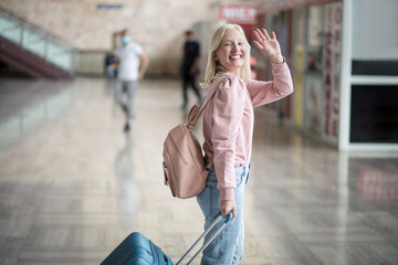  Woman on bus station standing and waving.