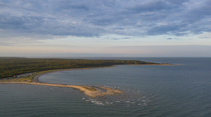 Aerail view to the sunlit spit next to the vast open sea 