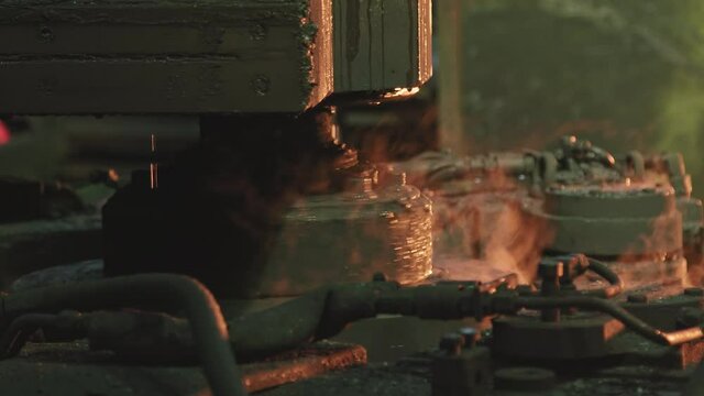 Close up of machine equipment working with heated iron and steel forming its shape at forging shop of tractor plant