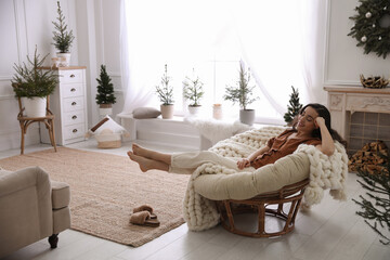 Woman resting in comfortable papasan chair at home