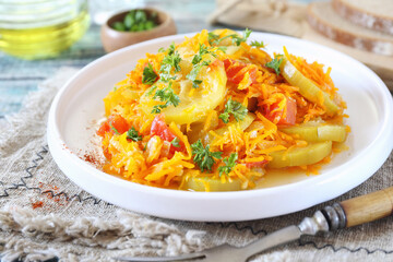 Vegetable side dish. Stewed zucchini with carrots and tomatoes, dressing parsley and olive oil