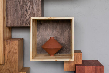 Minimalistic decorations of home interior - square wooden shelfs with  ceramic vases inside.