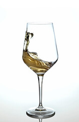 Copa de vino blanco sobre fondo blanco en movimiento