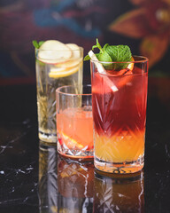 Cocktails with fruits and berries in a bar or restaurant. Blurred background. Alcoholic beverages.