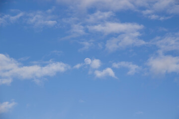 Cloud and the moon in the blue sky. A beautiful clouds against the blue sky background. Beautiful cloud pattern in the sky.