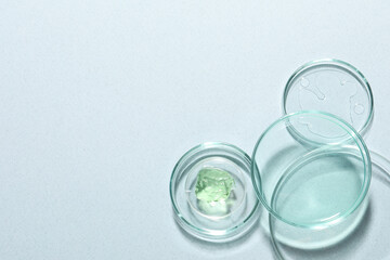 Organic cosmetic product and laboratory glassware on light background, flat lay. Space for text