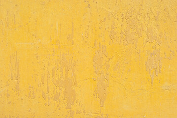 Plaster on a yellow wall. Concrete wall texture close up.
