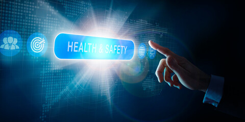 A businessmans hand selecting a Health and safety business word concept on a computer display.