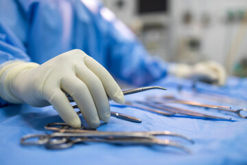 Close up photo selective focus of doctor's hands inside modern operating room in blue surgical gown...