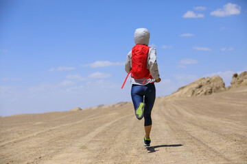 Fitness woman trail runner cross country running on sand desert