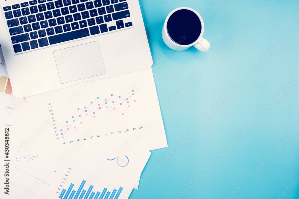 Poster laptop computer and documents report statistic financial with graph and chart and coffee on desk, fi