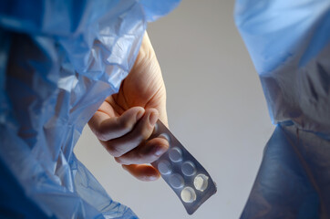 The hand throws the plate of pills into the trash.