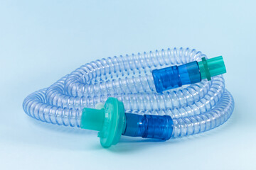 Tubing for CPAP or BIPAP machine with green filter isolated on blue background. Medical equipment