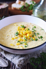 Corn Chowder. American cuisine. Creamy corn soup, green onions and parsley dressing