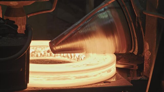 Close up of ring rolling process in forge shop. Professional ring rolling machine forging and rolling steel rings