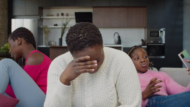 Portrait of sad disappointed black mother complaining about problems of family relationships, lack of communications from teenage daughters mobile phone addiction and online phone excessive use.