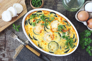 French cuisine. Vegetable zucchini clafoutis with goat cheese in ceramic bakeware - 430350827