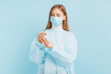 Doctor holding a vial with a dose of covid 19 corona virus vaccine for injection, on a blue background