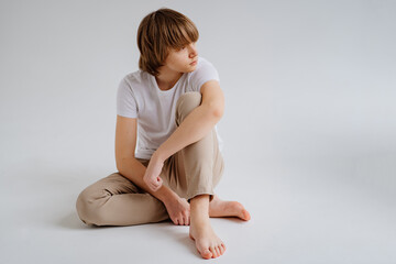teen boy in white T-shirt pose in a photo studio. problems for teenage boys. 