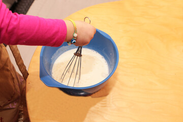 The girl helps her mother to cook.