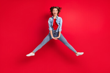 Full length body size photo of careless cheerful girl jumping up isolated on bright red color...