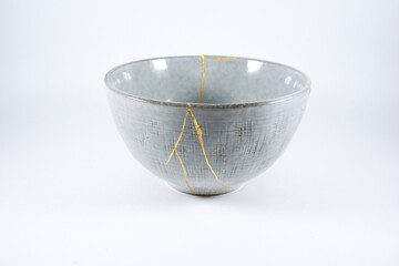 Grey broken pottery restored with Kintsugi, representation of broken heart with pottery.