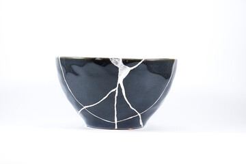 Silver Kintsugi, broken black bowl restored with silver