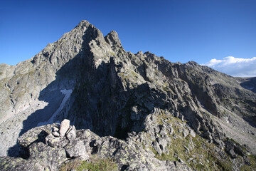 Difficult hiking trail going uphill through the rocks on steep mountain slope in Pirin national park, Bulgaria near Muratov peak and Vihren hut