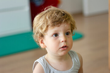 Child is sitting on a floor at home