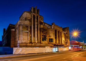 Harrow street by night with a London's red bus in motion and Art Deco cinema building before renovation, Harrow, England, 