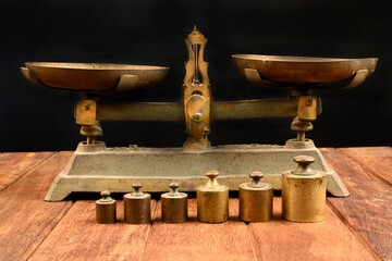 Old vintage balance scales, cast iron with old and rusty weights on dark background