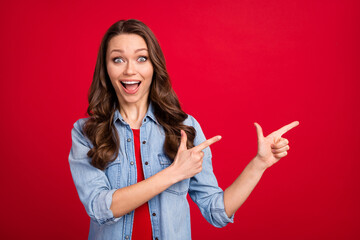 Photo portrait of brunette girl showing fingers copyspace overjoyed amazed isolated on bright red color background