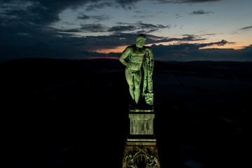 luftaufnahme vom der beleuchteten Spitze des Monumentalbau mit der Figur des Herkules bei Nacht,...