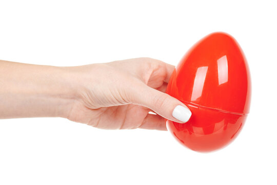 Hand with red plastic egg isolated on white background.