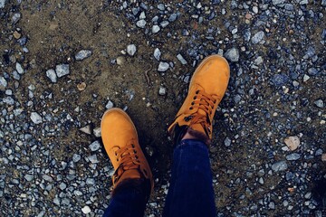 female feet in boots on the ground nature top view