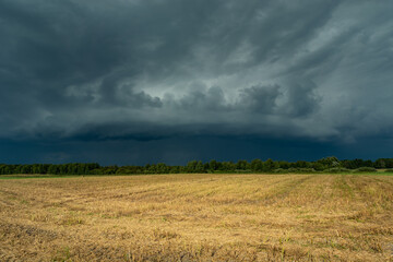 Fototapeta na wymiar Storm supercell in gray sky over agricultural fields, Czulczyce, Poland