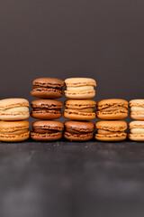 Stacks of brown, beige and cream colored French macarons with copy space