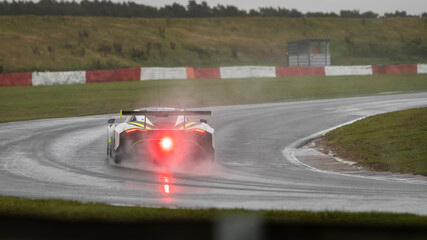 Fototapeta na wymiar A panning shot of a racing car as it circuits a track.