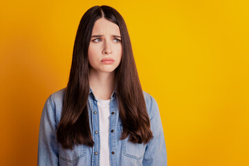 Fototapeta premium Closeup portrait woman frowning look empty space isolated yellow wall background