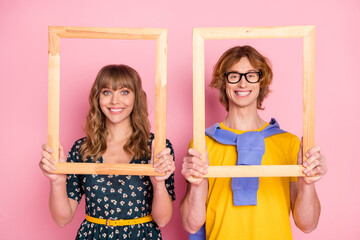 Photo of optimistic nice couple pose in frame wear colorful clothes isolated on pastel pink background