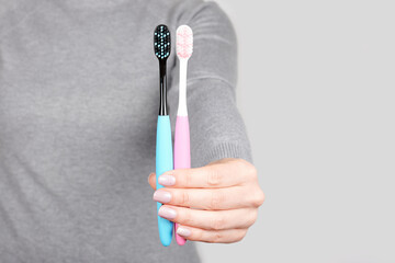 Hand with dental toothbrush on grey background
