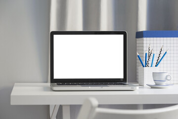 Laptop with blank screen on a home office table.	
