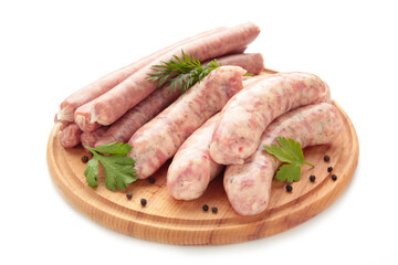 Raw sausages on cutting board isolated on white.
