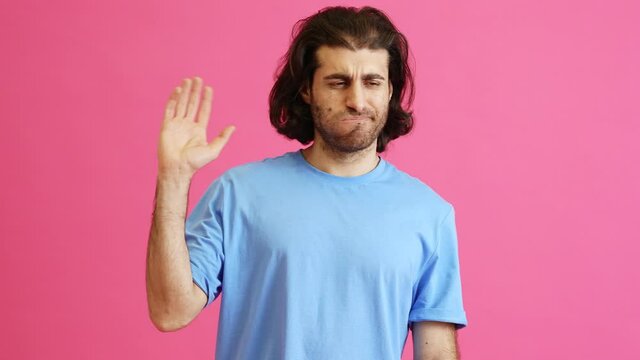 A man in misunderstanding raising his hand and leaving in a pink studio