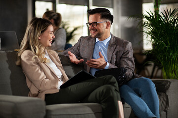 Colleagues talking in the office. Businesswoman and businessman discussing work in office..