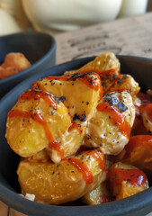 Patatas bravas con salsa picante, salsa alioli y sal negra